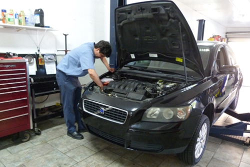 car-mechanic-working-under-the-hood-on-a-volvo