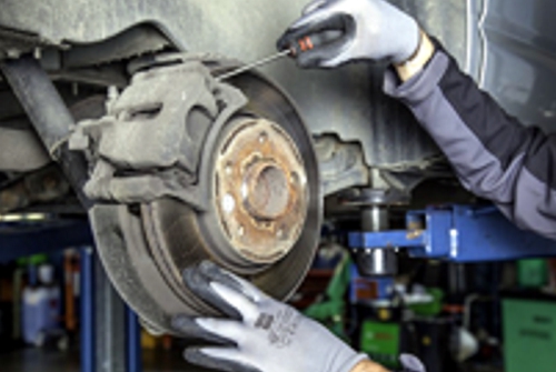 mechanic-changing-brake-pads on a vehicle