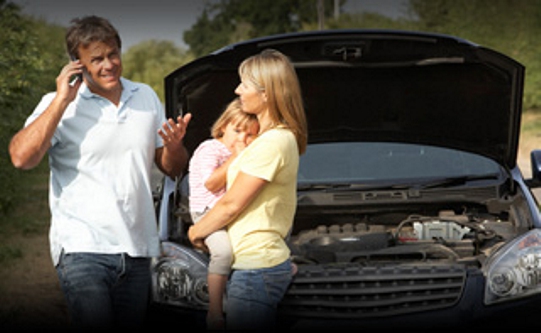family stranded with broken car man woman and a child outside a stranded car calling help