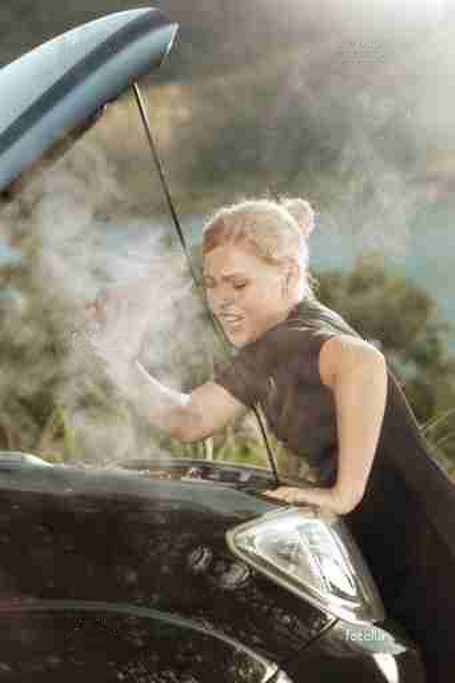 overheated-car woman under the hood of an overheated car